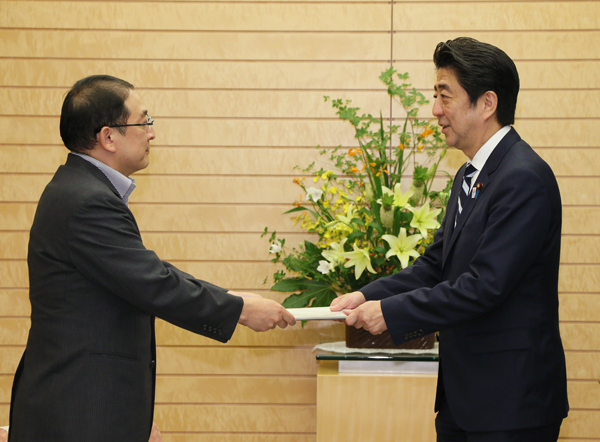 安倍总理在总理大臣官邸接收了故乡建设有识之士会议主席小田切德美递交的“故乡建设”推进中期报告。